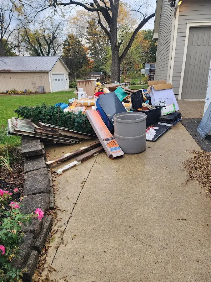 Dumpster being loaded with debris for 12 Yard Dumpster Rental in Minster